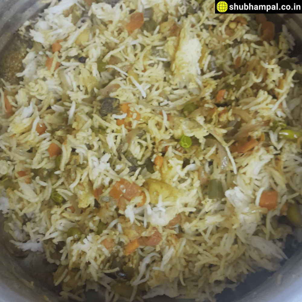 A plate of vegetarian pulao garnished with vegetables and herbs.